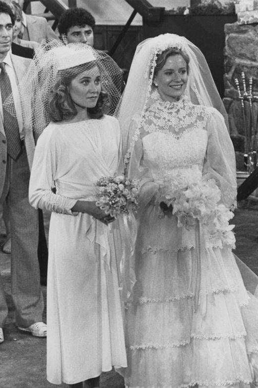 Maureen McCormick和Eve Plumb分別穿著褶皺中長設計婚紗和蕾絲落地婚紗。
