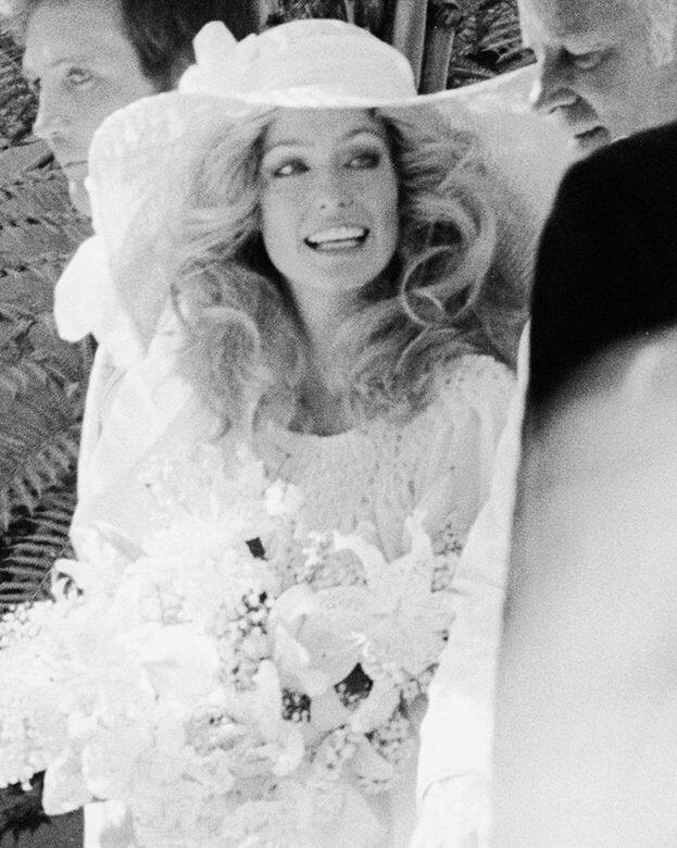 1973Farrah Fawcett這位第一代Charlie’s Angel穿上了全美版Bianca Jagger婚禮造型，嫁給Lee Majors，她帶著