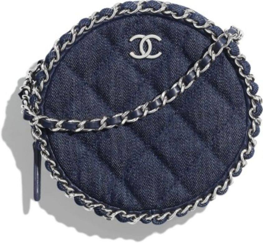 深藍色的丹寧圓形手袋上，綴有銀色的Chanel經典雙C標誌。藍色的肩帶和手