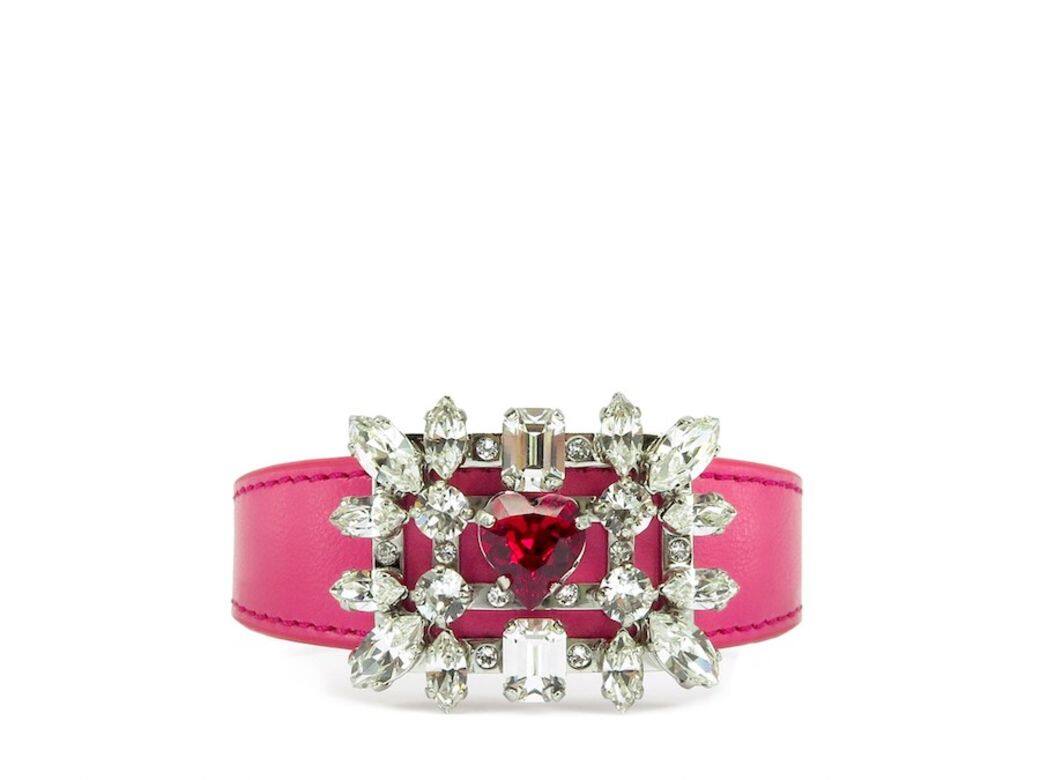 Roger Vivier 這款手鐲以粉紅色牛皮製成,綴以精巧的心形閃鑽飾扣,將 Broche 方扣與 Roger Vivier 這款手鐲以粉紅色牛皮製成,綴以精巧的心形閃鑽飾扣,將 Broche 方扣與