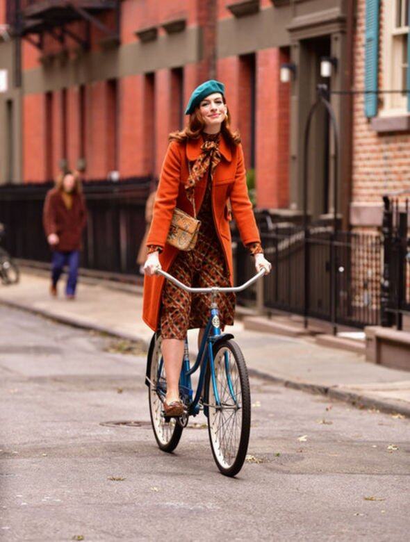 橙橘色格紋連身裙與長外套，配搭孔雀藍畫家帽的Anne Hathaway，以色彩及圖案打