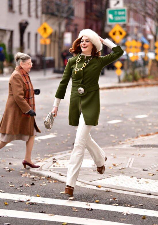 Anne Hathaway以白色長褲及高領毛衣作內搭，配搭誇張的塑膠頸鏈、橄欖綠色輪廓