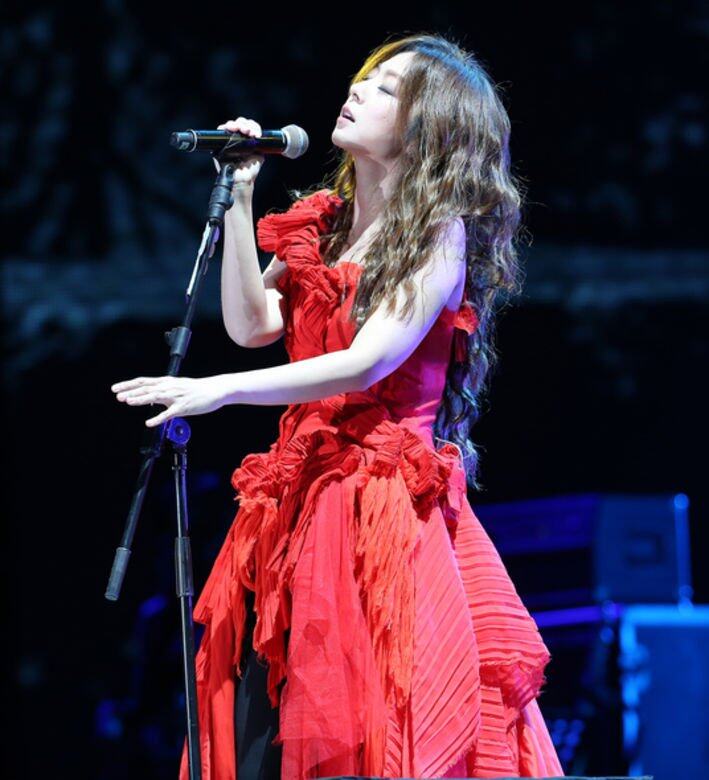 長髮飄飄的陳綺貞穿起大紅色層層疊裙子在演唱會上忘情演出，場面感