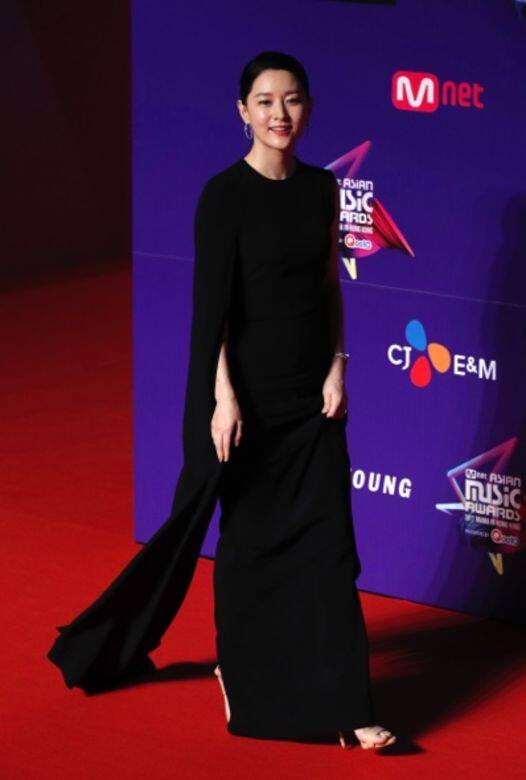 近年，李英愛則偏好舒適自在的連身裙，走紅毯選擇斗篷款鬆身黑裙，一邊