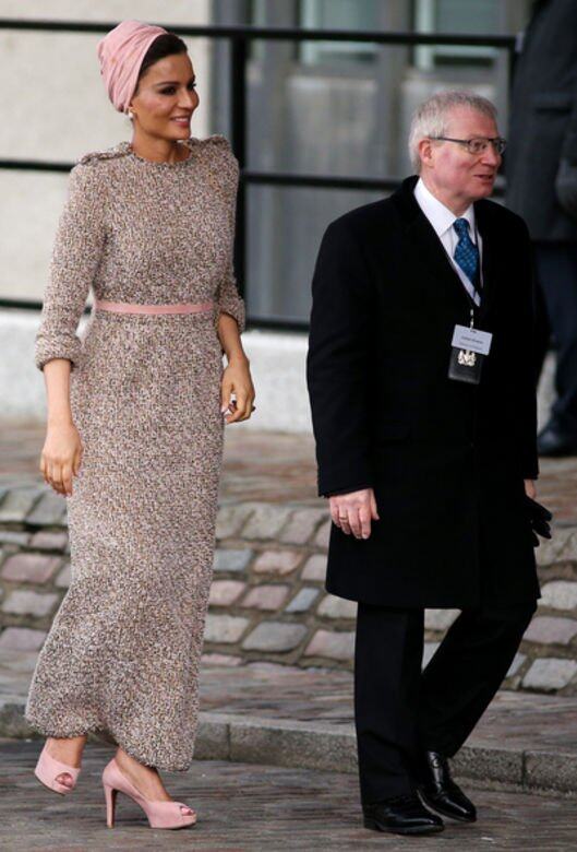 優雅的淺啡色呢絨修身長裙，配襯粉紅色頭巾和高跟鞋，帶出卡塔爾王妃