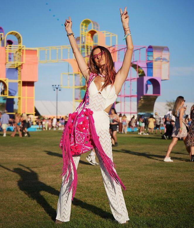 Alessandra Ambrosio一身波希米亞風格的連身褲配搭超搶眼的粉紅色流蘇斜揹袋，波浪