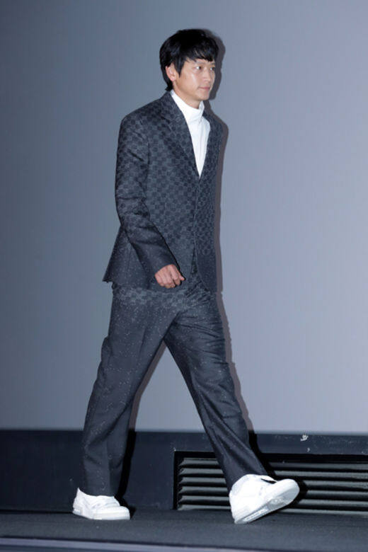 回到首爾的首映禮時，姜棟元穿上LV的格紋圖案西裝套裝，配上白色高領