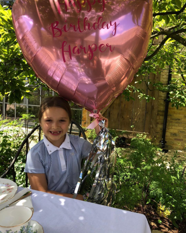 7歲生日的Harper拿著粉紅色汽球，上面寫著「Happy Birthday Harper」，她開心得露出了甩了門