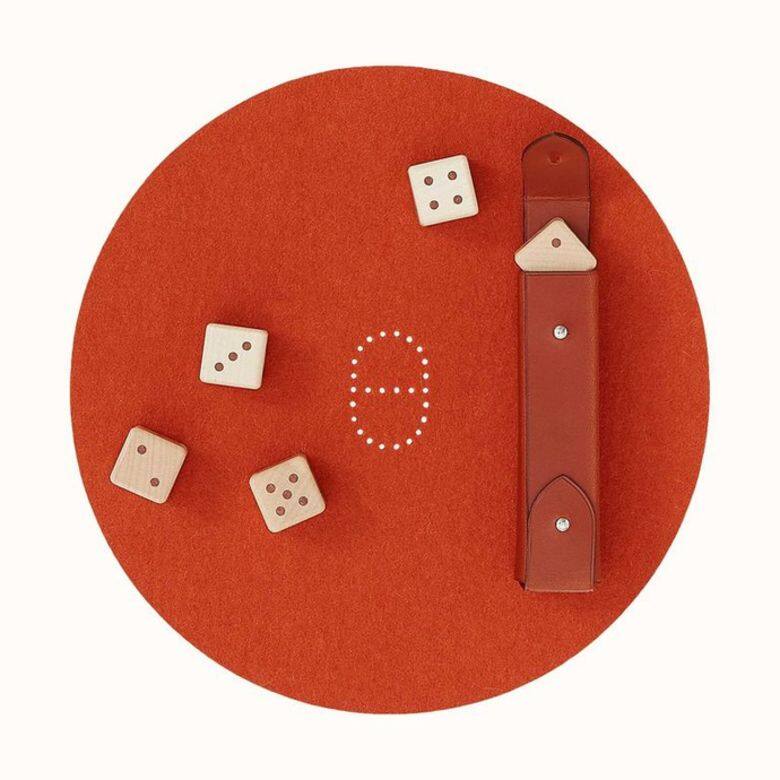 以楓木鑲嵌製成的骰子，搭配愛馬仕橙的羊皮封套、墊子，不僅配色看起來