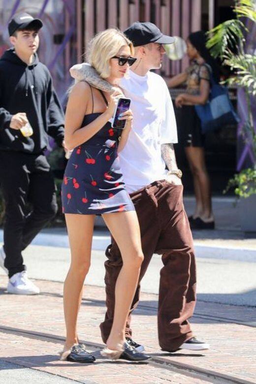 Justin Bieber穿著白色T-Shirt與闊腳褲，Hailey Bieber則是穿著櫻桃圖案的短連身裙，兩人風