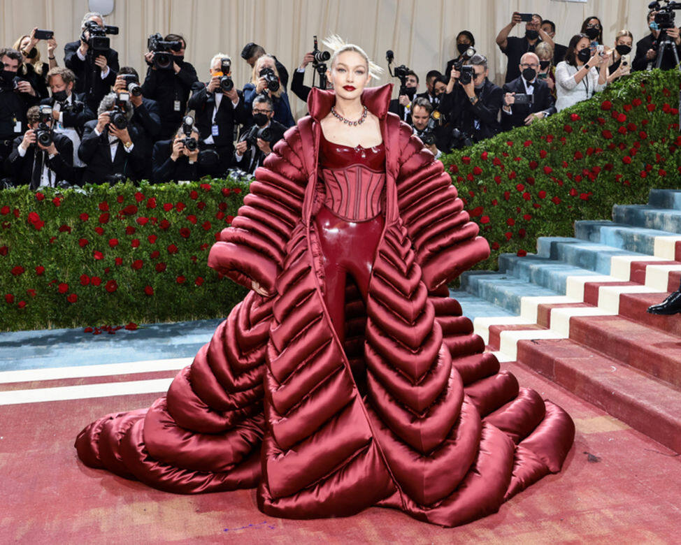 姐姐Gigi Hadid就以Atelier Versace訂製的紅色禮服登場，氣場大開，巨形的拖地puff jacket極搶