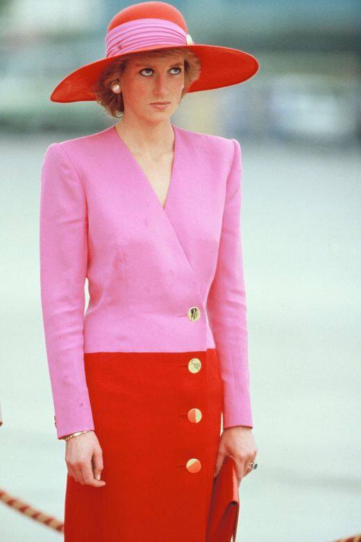 全身粉紅色配紅色的穿搭，從帽子到墊肩拼色大衣，不論是色調還是剪裁