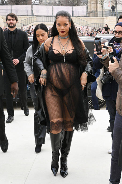 Rihanna出席Dior FW22 fashion show，向來風格大膽的她，選擇了黑色薄紗吊帶連身裙，款式