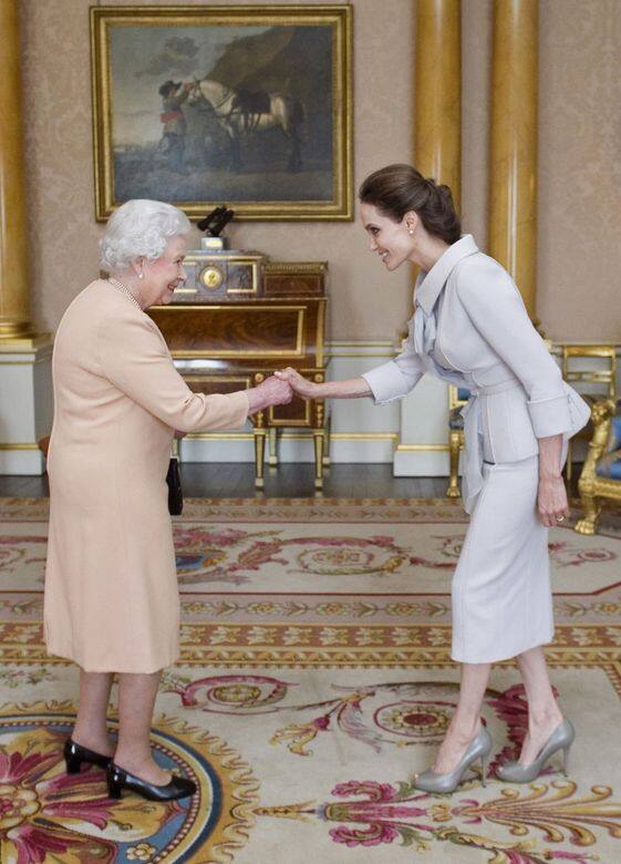 2014年,Angelina Jolie穿上淺灰色的兩件式過膝套裝,配搭灰色高跟鞋,盤起頭髮,優雅 2014年,Angelina Jolie穿上淺灰色的兩件式過膝套裝,配搭灰色高跟鞋,盤起頭髮,優雅