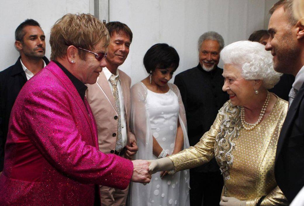 同場還有Elton John，穿上桃紅色亮片西裝晉見英女王，