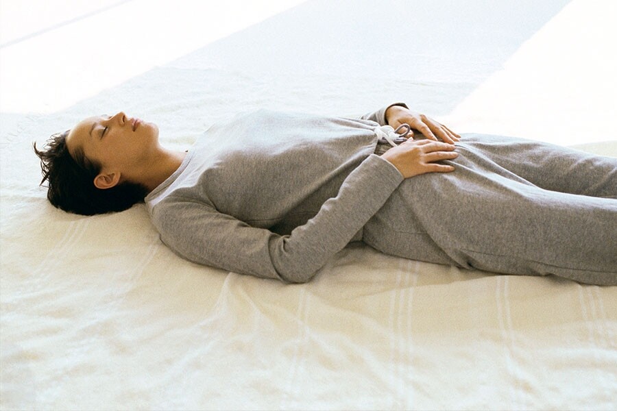 先躺在瑜伽墊上（或是坐着也可），盡量用鼻子大大吸一口氣，吸氣同時脹大