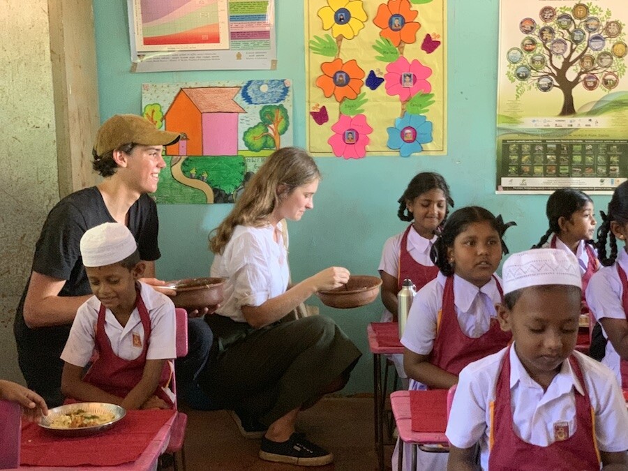 帥氣的 Paris Brosnan(左)跟 Lauren 一起給學童們送上午餐，出心出力的Paris更為此行製作了紀錄片呢!