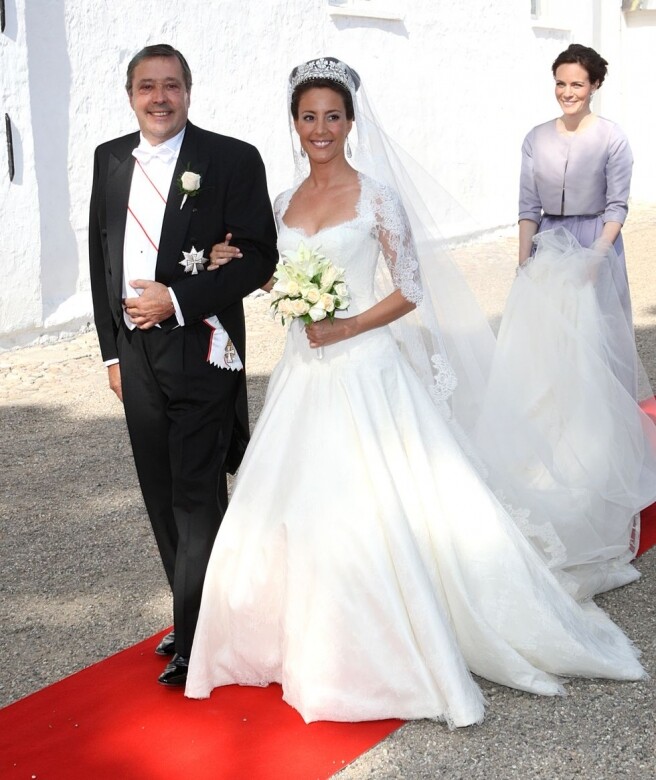 丹麥王妃Princess Marie of Denmark的婚紗由Arasa Morelli打造，上半部分的繡花緊身胸衣突顯新