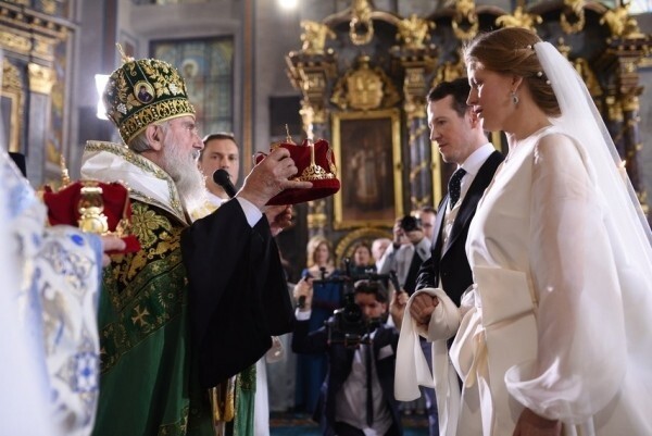 這對幸福的新人在城市的大教堂舉行傳統儀式時，戴著精緻的冠冕交換
