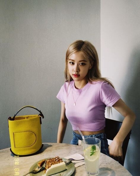 韓國人氣女團BLACKPINK成員Rosie以粉色短上衣配上鮮Delvaux黃色Pin水桶袋，讓整體看