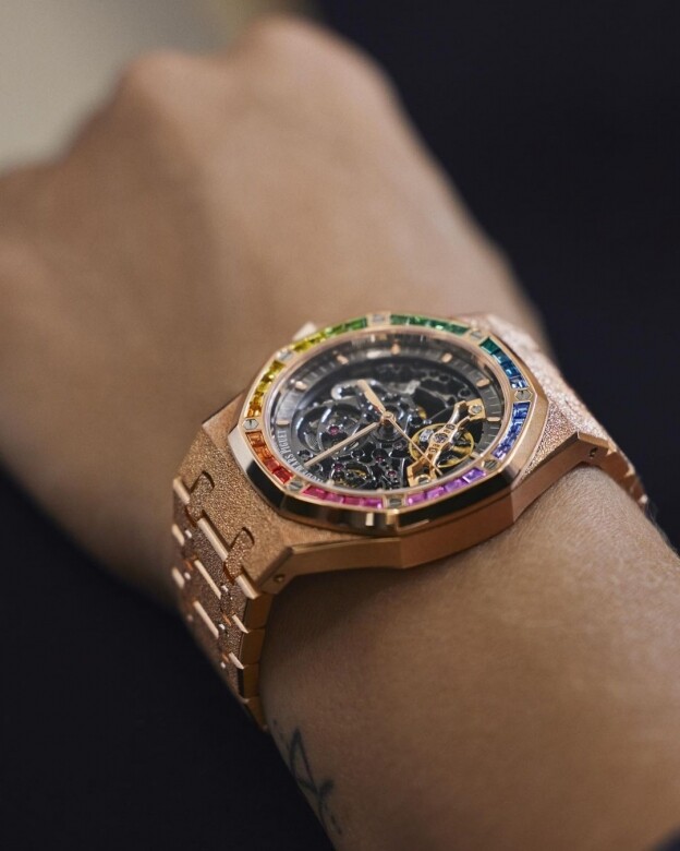 由七彩寶石組成的彩虹色錶圈，為霜金18K玫瑰金錶殼及錶帶增添美感