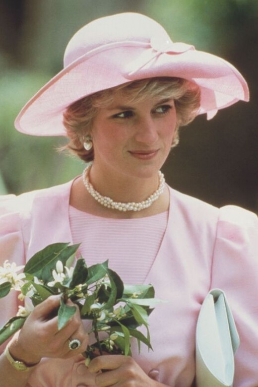 繩鍊款的珍珠項鍊搭配Catherine Walker、黛妃最愛品牌的粉色洋裝、John Boyd禮帽。優雅得