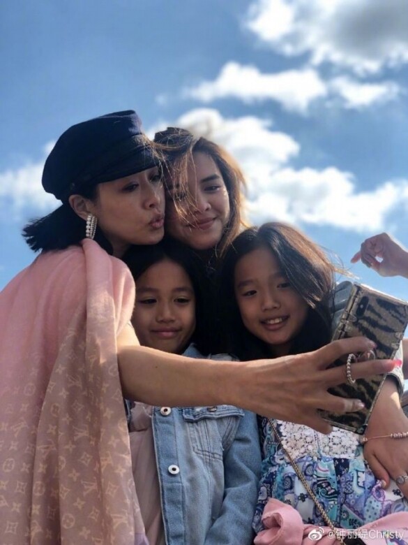 披著LV淺粉紅色圍巾的Christy摟著三個女兒一起拍照，湊起來就像是四姊妹