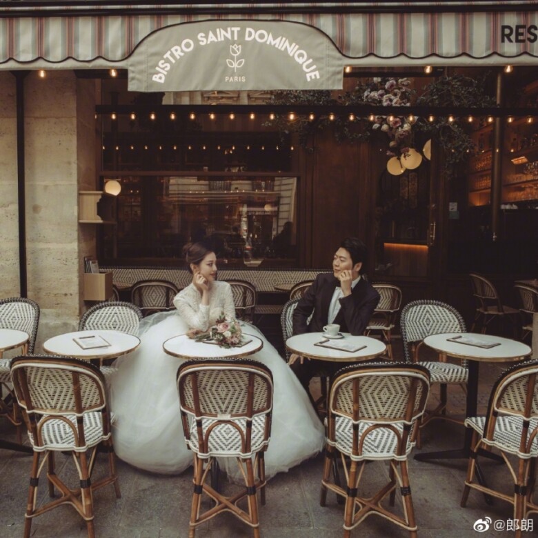 一對新人坐在巴黎咖啡廳戶外拍照，Gina Alice換上公主式長袖婚紗與郎朗情