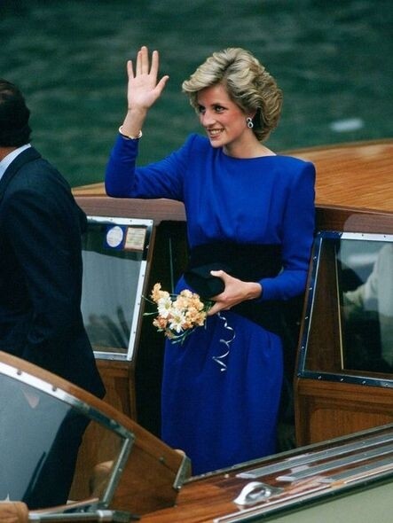 1985年親民的王妃穿著這身寶藍色Bruce Oldfield連身裙向群眾揮手示好。