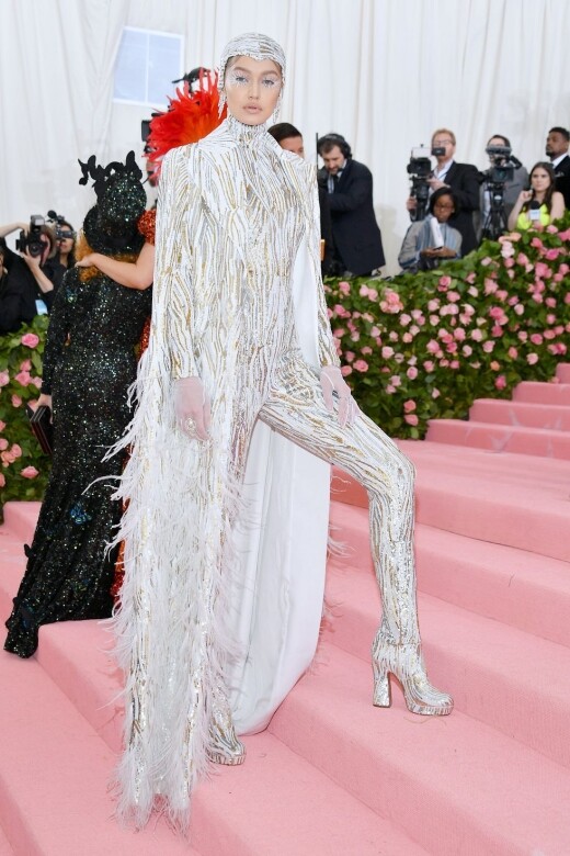 超模Gigi Hadid身著訂製款金銀亮片羽毛刺繡披肩，內穿銀色金色亮片薄紗連