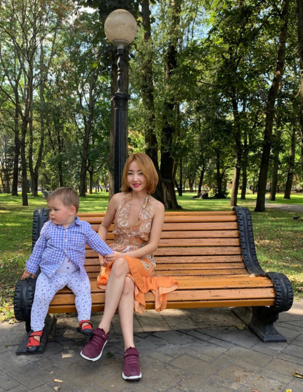 朴研美穿上低胸花紋夏日連身裙與兒子坐在長椅上享受日光浴。兒子肉