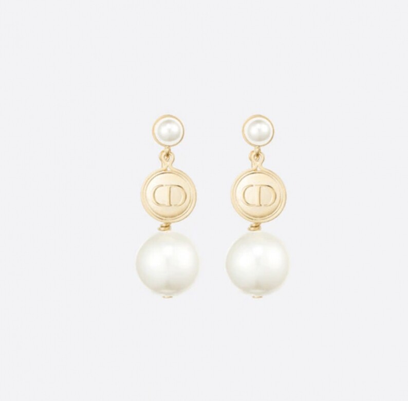 珍珠是品牌常用的設計元素，這款耳環同樣加入「CD」標誌徽章，珍珠點綴更