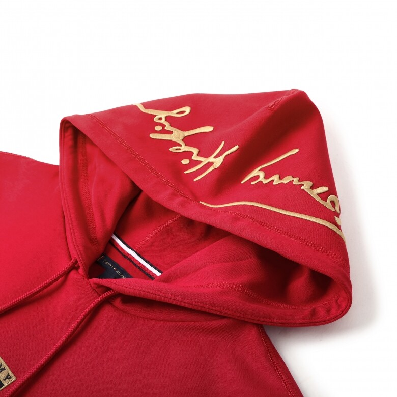 紅色休閒風格的衞衣，帽子位置加入金色Tommy Hilfiger字樣，簡單又時尚。