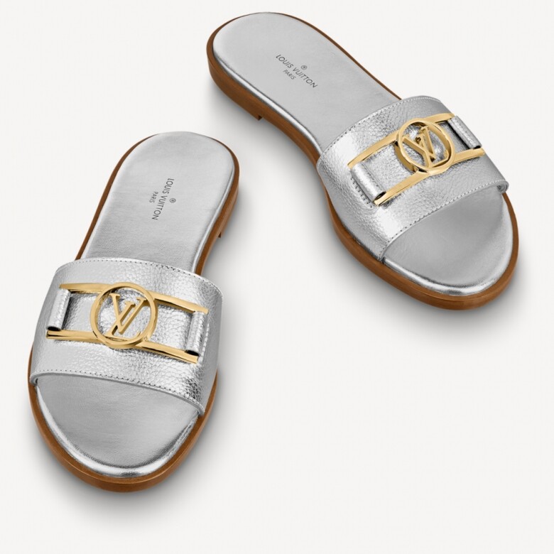 Louis Vuitton Lock It 平底拖鞋絕對是夏天必備的款式，鞋款配有寬闊的前搭帶，銀色