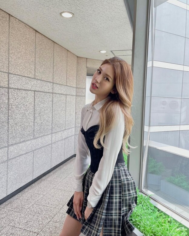 現在才20歲的Somi穿上學院風格的短裙造型毫無違和感，恤衫外加一件馬