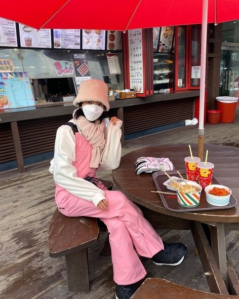 金智恩去滑雪，選擇了一條粉紅色工人褲，充滿少女味。米色毛毛漁夫帽和