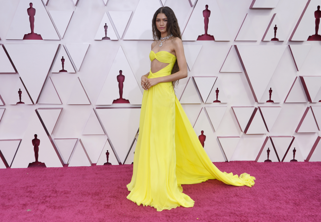 Zendaya 一身火辣的螢光黄色連身裙出自Valentino手筆，度身定制的剪裁把她的身材