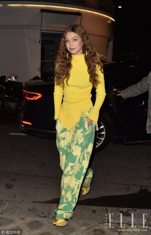 直筒休閒褲，Gigi Hadid巧妙地配了黃色緊身冷衫上緊下鬆，側邊開衩的款式顯