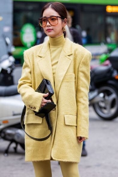 檸檬黃的西裝外套屬於俏皮年輕的風格，搭配橘色漸層墨鏡，時尚又能顯