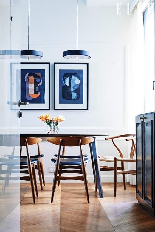 飯廳的藝術畫作，色系跟客廳的經典藍櫃門配合得天衣無縫。