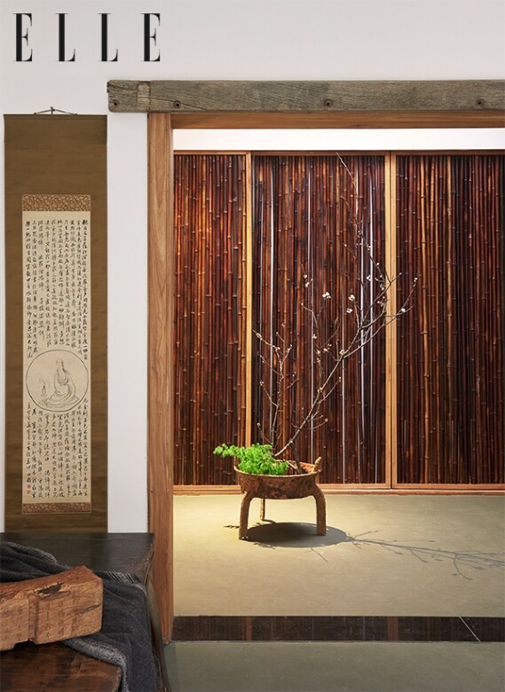 和臥室相連的衣帽間，用百年老竹子做的衣櫃門。 左邊是一張古人小憩的木榻，上面放置的木枕上刻着主人的書法作品。