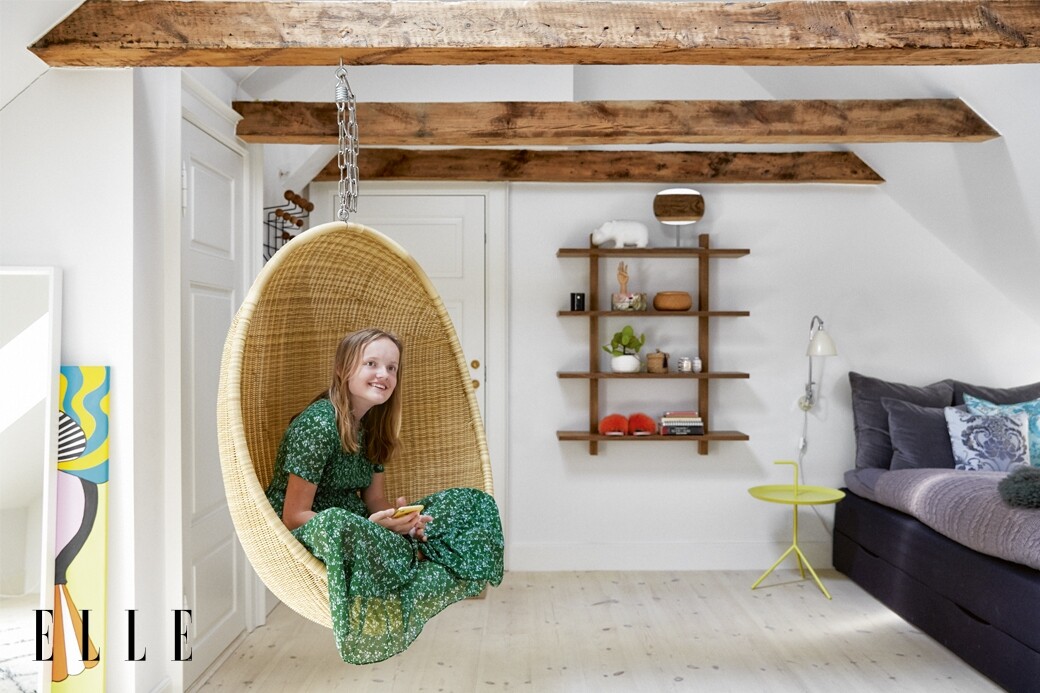 小女兒的房間有自己的獨立門口，外露的木橫樑和藤吊椅很合襯。