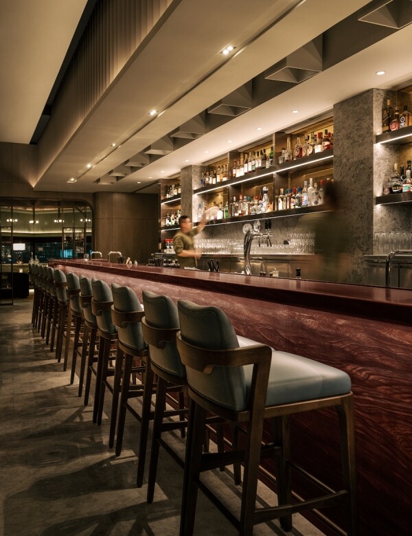 主用餐區對面的長吧台，以質樸的巴西棕紅雲石鋪砌，甚有格調。