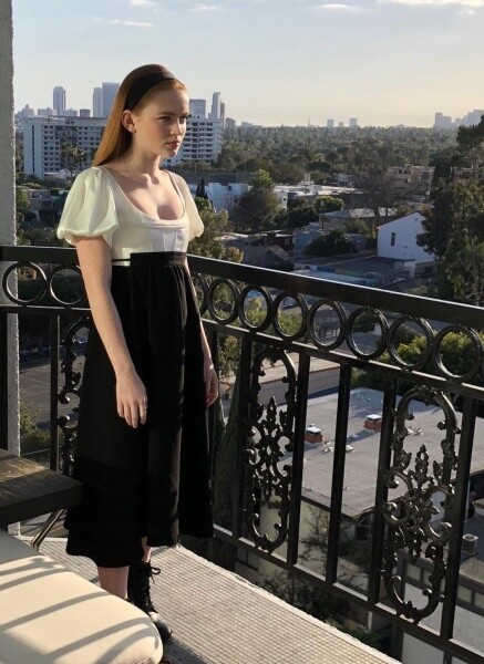 黑白色的低胸禮服，把頭髮夾直，以貼服的直髮配上簡單的黑色的粗頭帶