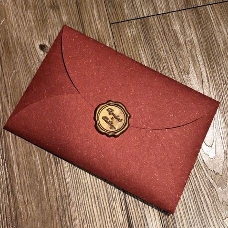 兩人的喜帖用紅色信封裝，並以刻有雙方姓名的封蠟章封口。
