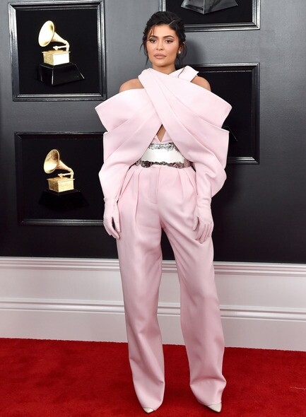 Kylie Jenner一身Balmain高訂粉紅色交衩、闊袖Jumpsuit，手袖結合了手襪的設計，玩味十足。