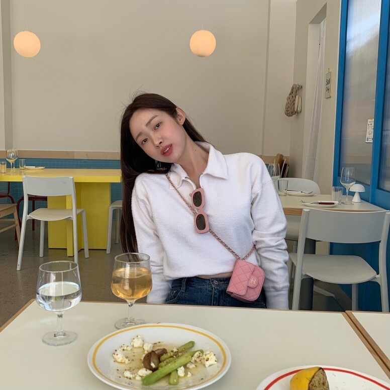 車靜媛很擅長為簡約穿搭添上可愛的配飾重點，這身白色長袖polo上衣和