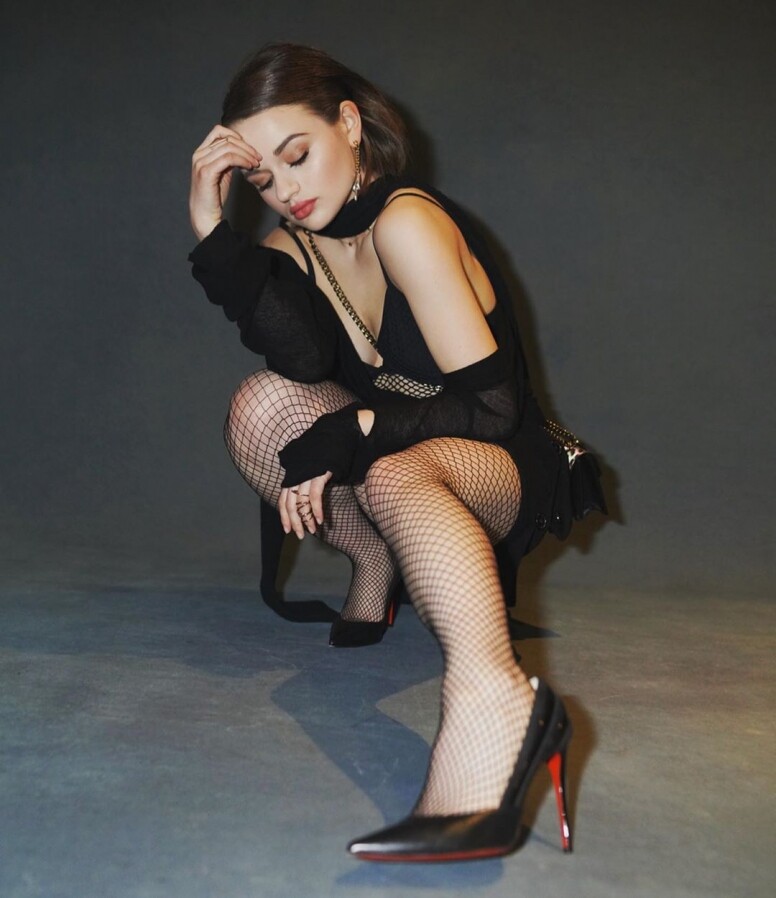 Joey King穿上深V黑色低胸裙，配搭漁網絲襪和紅底高跟鞋，展現有別於平時