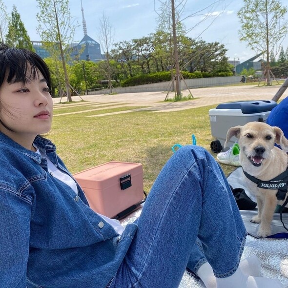 李周映以double denim造型跟朋友野餐，深色牛仔褲和同色牛仔褲，內搭純白恤，整