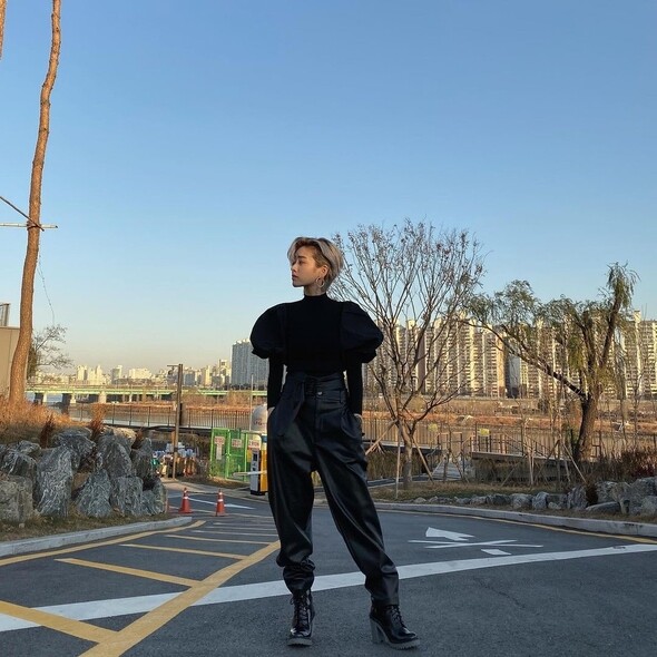 李周映穿上肩部誇張設計的黑色高領長袖上衣，配上闊皮褲和高跟綁帶